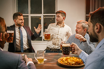 Image showing Group of friends enjoying evening drinks with beer