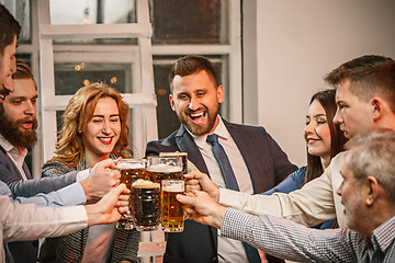 Image showing Group of friends enjoying evening drinks with beer