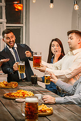 Image showing Group of friends enjoying evening drinks with beer