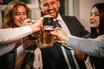 Image showing Group of friends enjoying evening drinks with beer