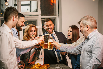 Image showing Group of friends enjoying evening drinks with beer