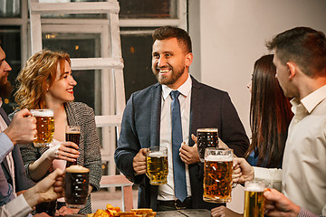 Image showing Group of friends enjoying evening drinks with beer