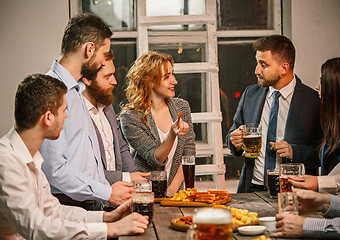 Image showing Group of friends enjoying evening drinks with beer