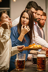 Image showing Group of friends enjoying evening drinks with beer