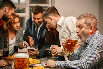 Image showing Group of friends enjoying evening drinks with beer