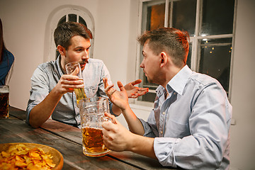 Image showing Group of friends enjoying evening drinks with beer