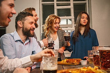 Image showing Group of friends enjoying evening drinks with beer