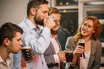 Image showing Group of friends enjoying evening drinks with beer