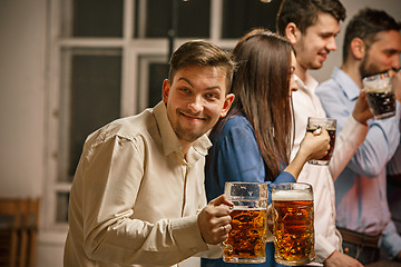 Image showing Group of friends enjoying evening drinks with beer