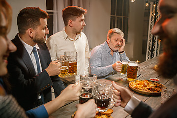 Image showing Group of friends enjoying evening drinks with beer