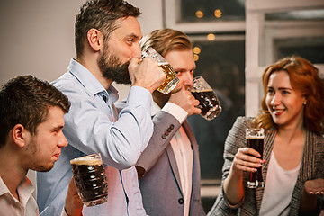 Image showing Group of friends enjoying evening drinks with beer