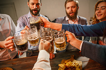 Image showing Group of friends enjoying evening drinks with beer