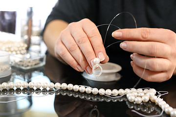 Image showing Jeweler, a pearl necklace Pearl earrings, a jeweler creates jewelry