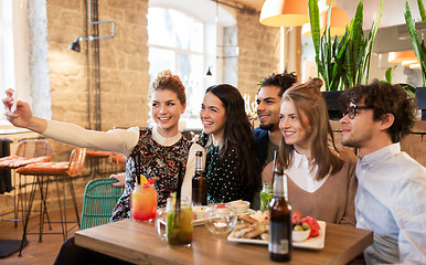 Image showing friends taking selfie by smartphone at bar or cafe