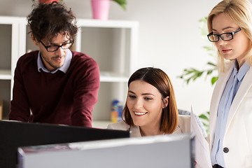 Image showing happy creative team with computer in office