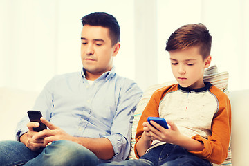 Image showing father and son with smartphones at home