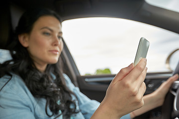 Image showing woman driving car with smarhphone