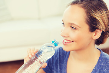 Image showing happy woman with water bottle at home
