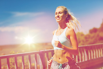 Image showing smiling young woman running outdoors