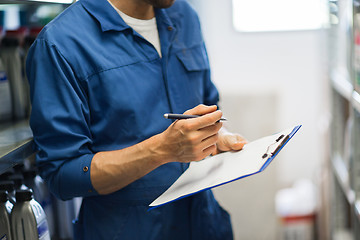 Image showing auto mechanic with clipboard at car workshop
