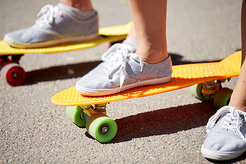 Image showing close up of female feet riding short skateboard