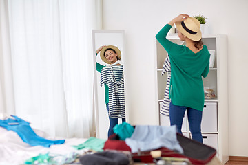 Image showing woman packing travel bag at home or hotel room