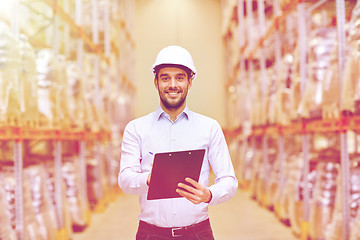 Image showing happy businessman with clipboard at warehouse