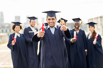 Image showing happy student with diploma pointing finger at you