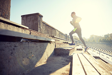 Image showing happy young man running upstairs on stadium