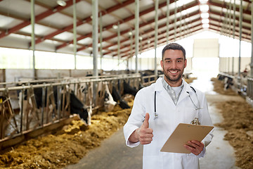 Image showing veterinarian with cows showing thumbs up on farm