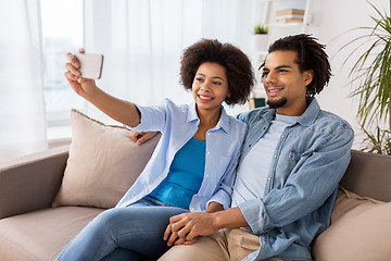 Image showing happy couple with smartphone taking selfie at home