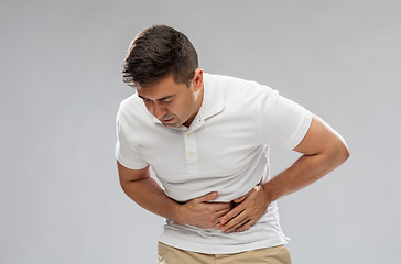 Image showing unhappy man suffering from stomach ache