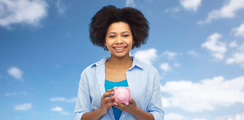 Image showing happy afro american young woman with piggy bank