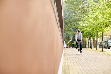 Image showing young man riding bicycle on city street