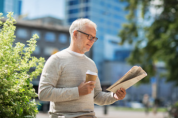 Image showing senior man reading newspaper and drinking coffee