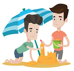 Image showing Male friends building sandcastle.