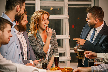 Image showing Group of friends enjoying evening drinks with beer