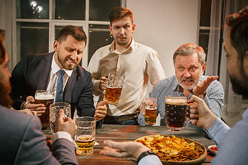 Image showing Group of friends enjoying evening drinks with beer