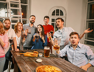 Image showing Group of friends enjoying evening drinks with beer