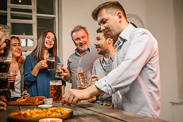 Image showing Group of friends enjoying evening drinks with beer