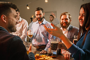 Image showing Group of friends enjoying evening drinks with beer