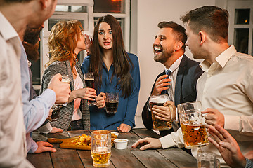 Image showing Group of friends enjoying evening drinks with beer