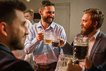 Image showing Group of friends enjoying evening drinks with beer