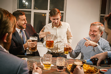 Image showing Group of friends enjoying evening drinks with beer