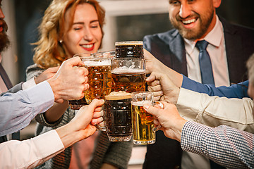 Image showing Group of friends enjoying evening drinks with beer