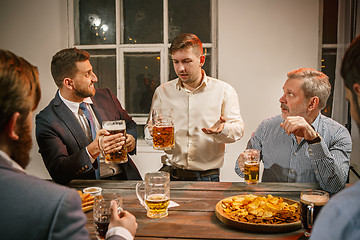 Image showing Group of friends enjoying evening drinks with beer