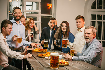 Image showing Group of friends enjoying evening drinks with beer