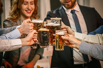 Image showing Group of friends enjoying evening drinks with beer