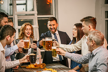 Image showing Group of friends enjoying evening drinks with beer