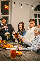 Image showing Group of friends enjoying evening drinks with beer